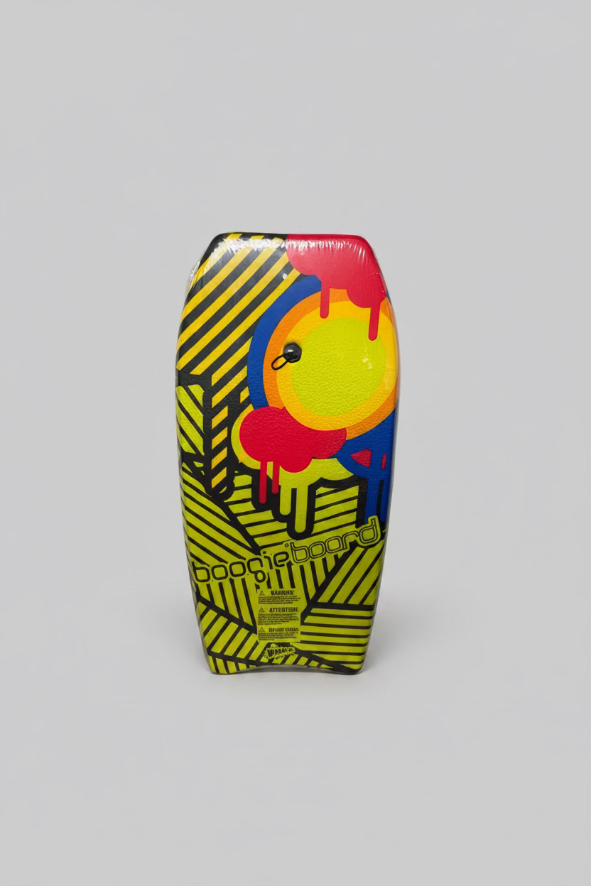 A brightly colored bodyboard standing upright against a white cardboard box. The board features a bold yellow and black striped base with a large central graphic in red, yellow, blue, and orange, and the words 'boogieboard' printed near the bottom.